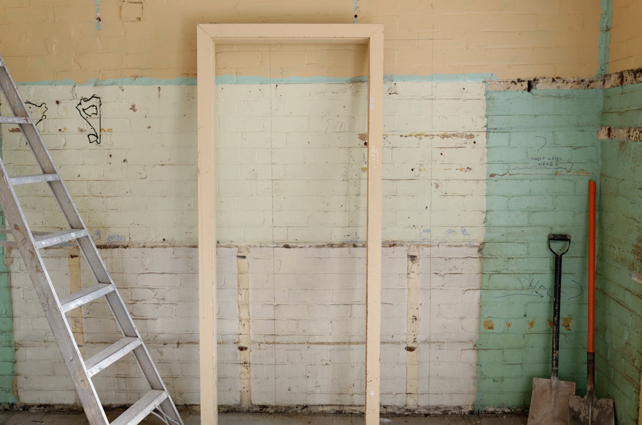heros-img Renovation scene featuring ladder, frame, and tools against partially demolished walls.